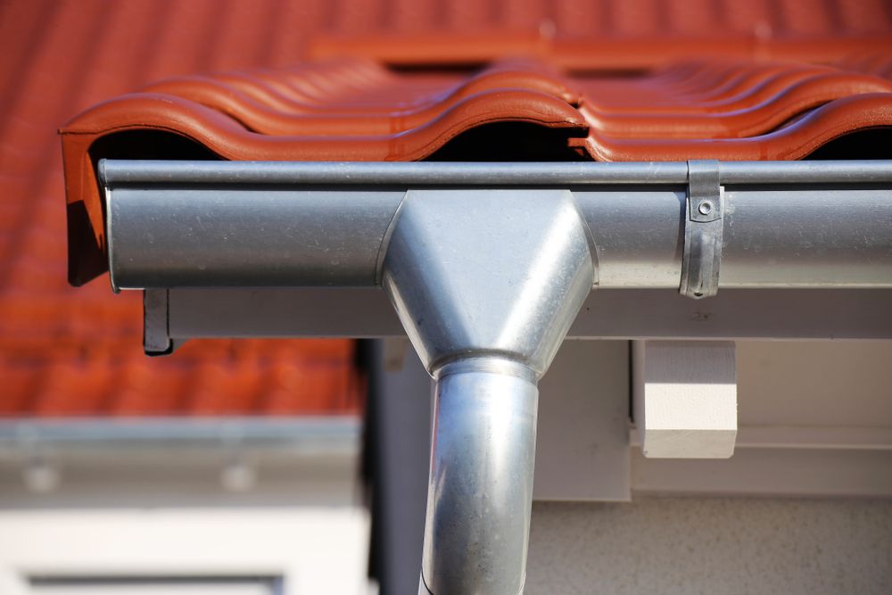 A Close Up of a Gutter on a Roof With a Red Tile Roof — Norwest Roof Restorations In Blue Bay, NSW