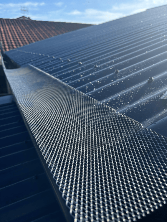 A Close Up of a Gutter on Top of a Roof — Norwest Roof Restorations In Blue Bay, NSW