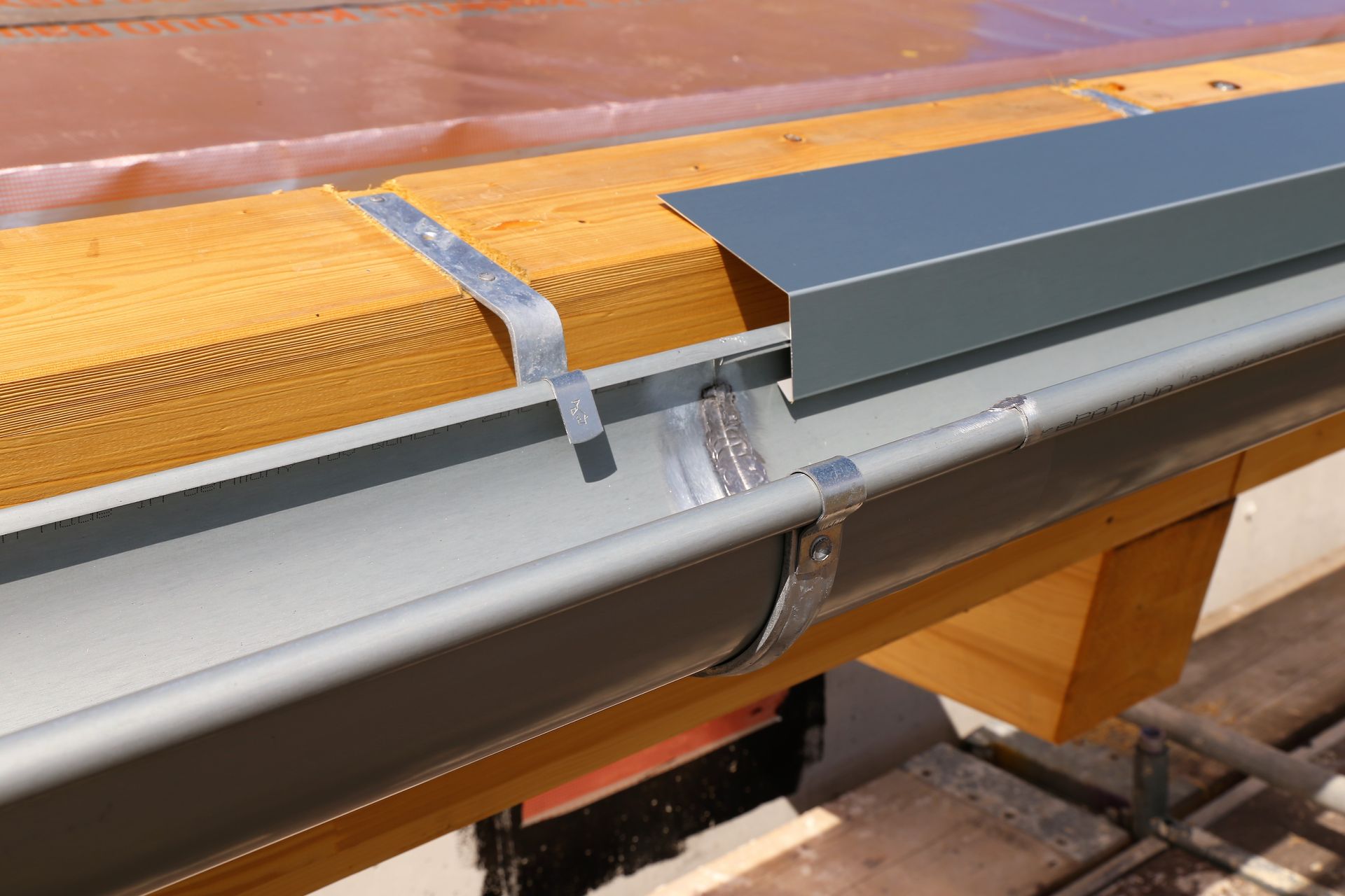 A Gutter is Being Installed on a Wooden Roof — Norwest Roof Restorations In Blue Bay, NSW