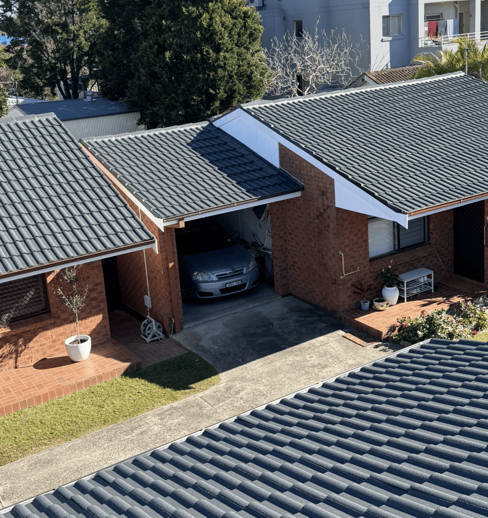 A Metal Roof With Overlapping Brown Tiles — Norwest Roof Restorations In Blue Bay, NSW