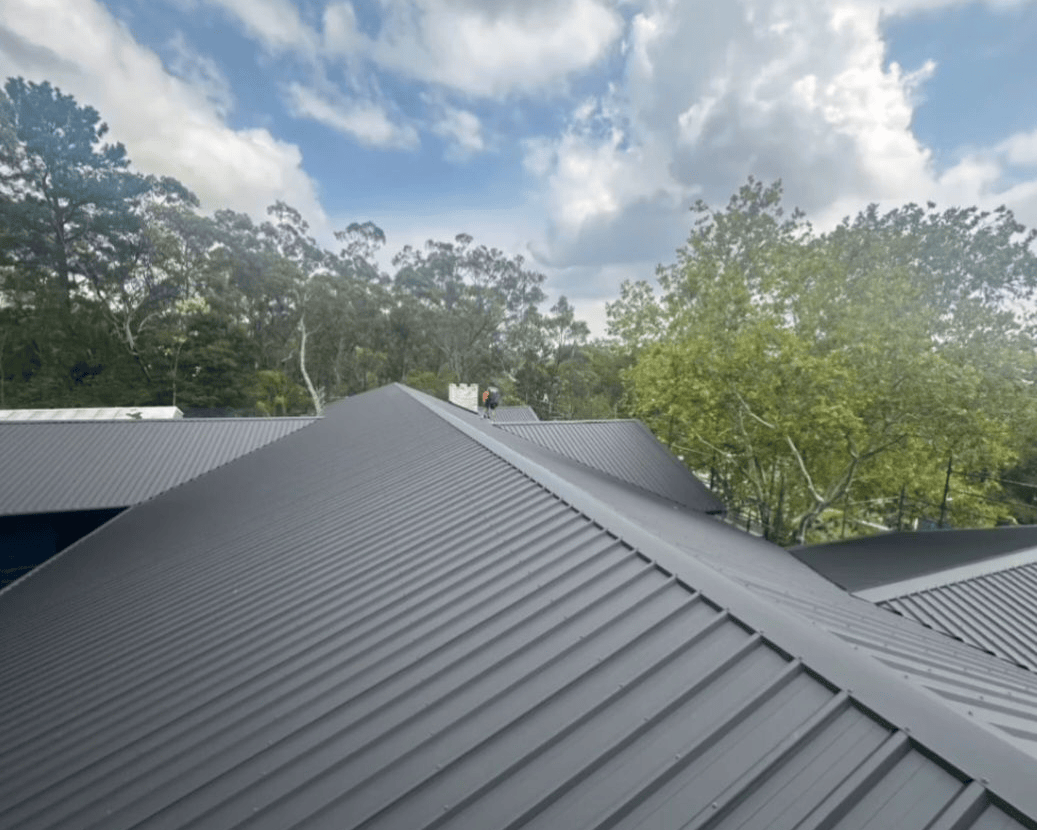 Metal Roof With Ridges Under a Cloudy Sky — Norwest Roof Restorations In Lake Macquarie, NSW