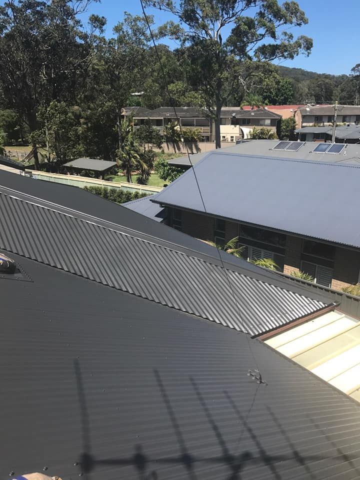 Rooftop View of Dark and Light Metal Roofs in a Suburban Area — Norwest Roof Restorations In Blue Bay, NSW