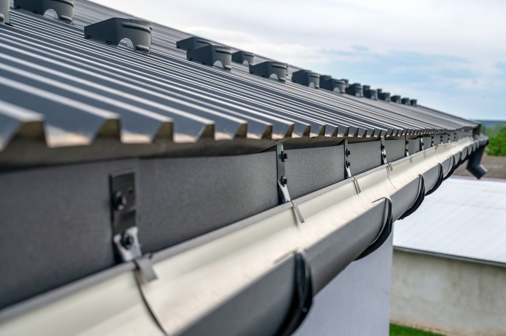 Row of Roof Panels and Gutters Along a Building — Norwest Roof Restorations In Lake Macquarie, NSW