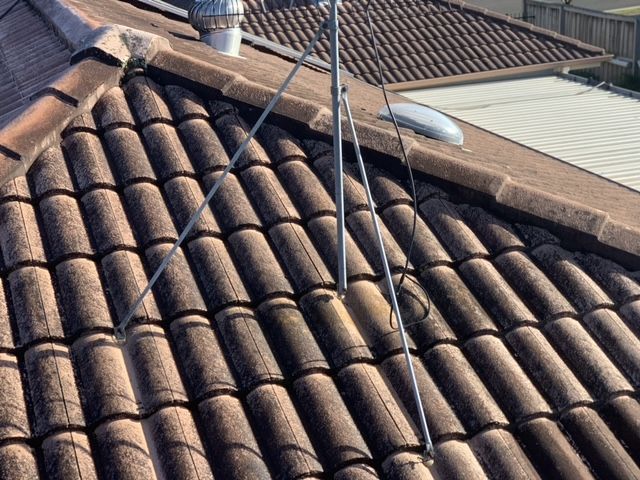 Terracotta Roof Tiles With Antennas and a Satellite Dish — Norwest Roof Restorations In Blue Bay, NSW