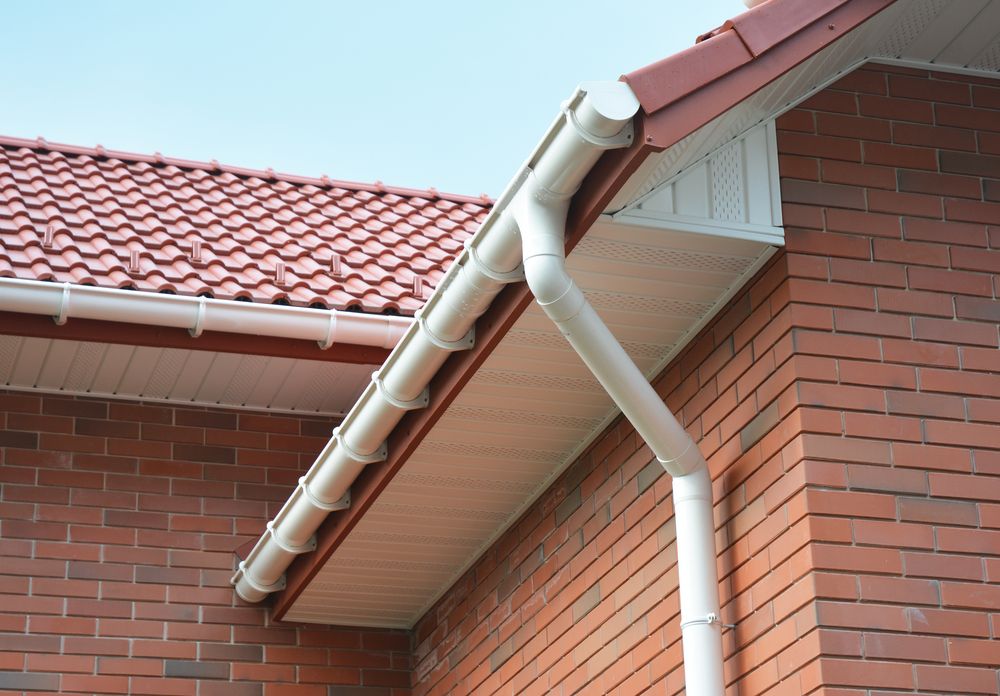 White Downspout and Gutter on a Red Brick House — Norwest Roof Restorations In Blue Bay, NSW